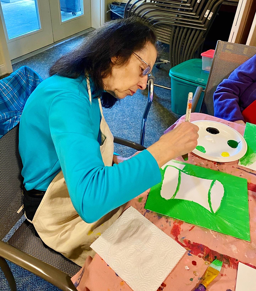 Resident painting in an activity room