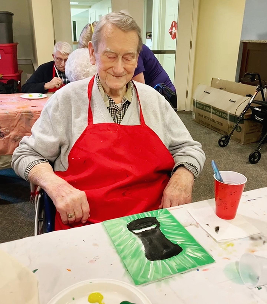 Resident painting during an art activity in the facility.