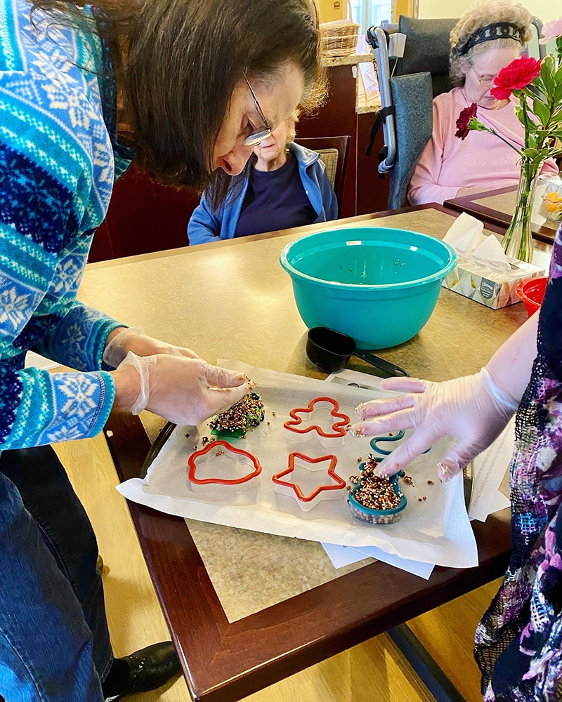 Residents decorating holiday cookies in a common area