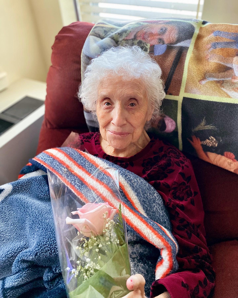 Resident holding a flower while sitting comfortably