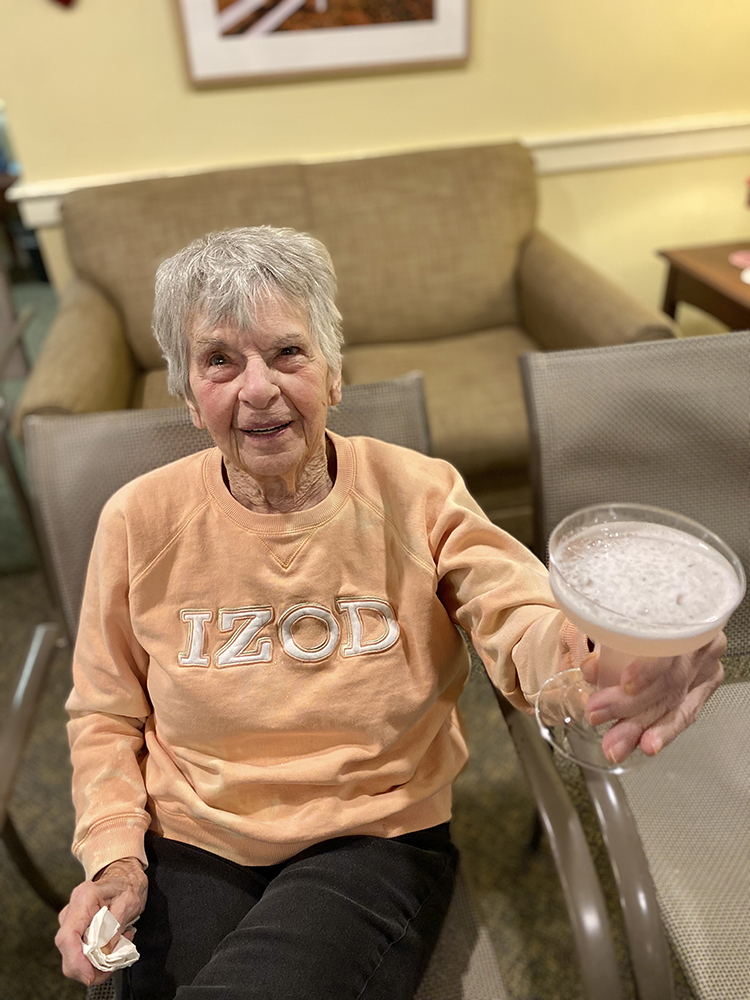 Resident enjoying a drink in a cozy common area