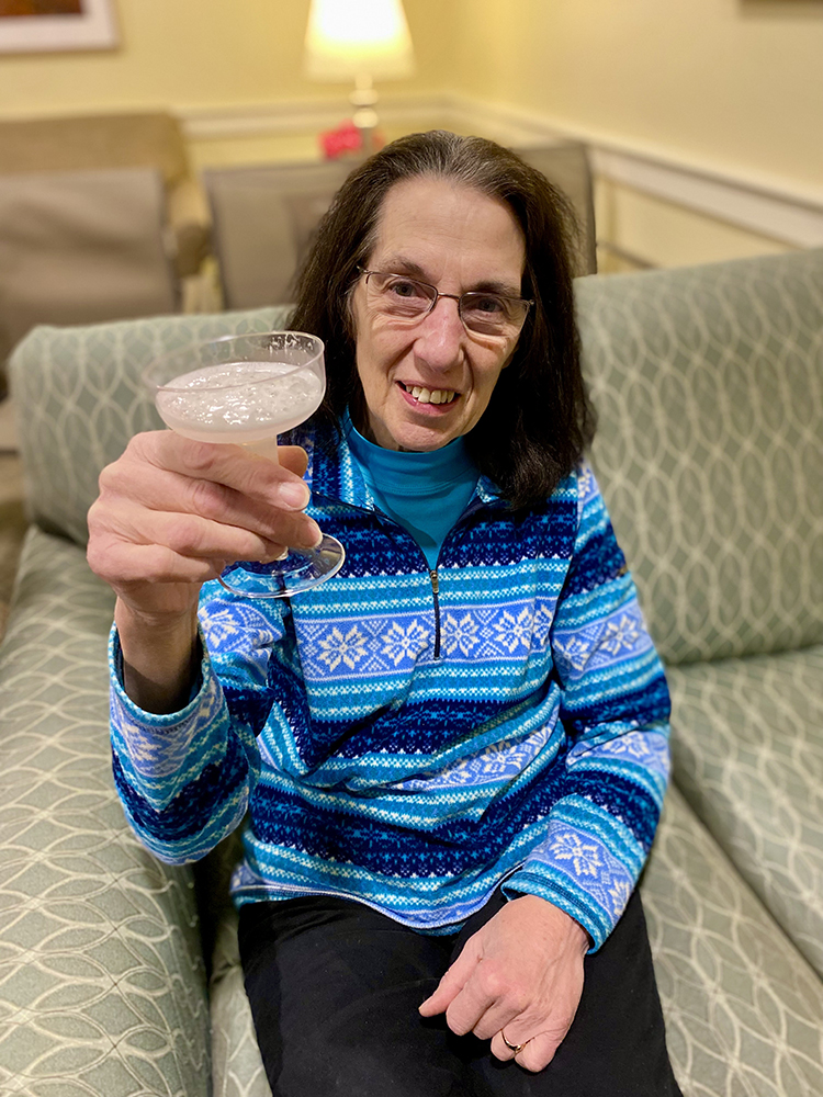 Resident celebrating with a drink in a social area
