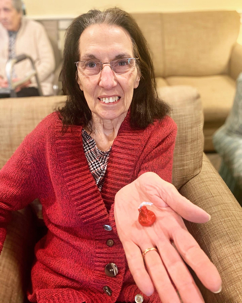 A resident happily displaying a heart-shaped object.