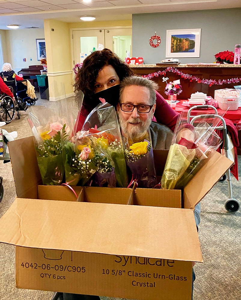 Residents celebrating with flowers in a decorated common area