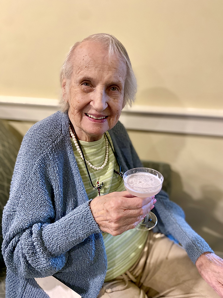 A happy resident enjoying a drink in a cozy setting