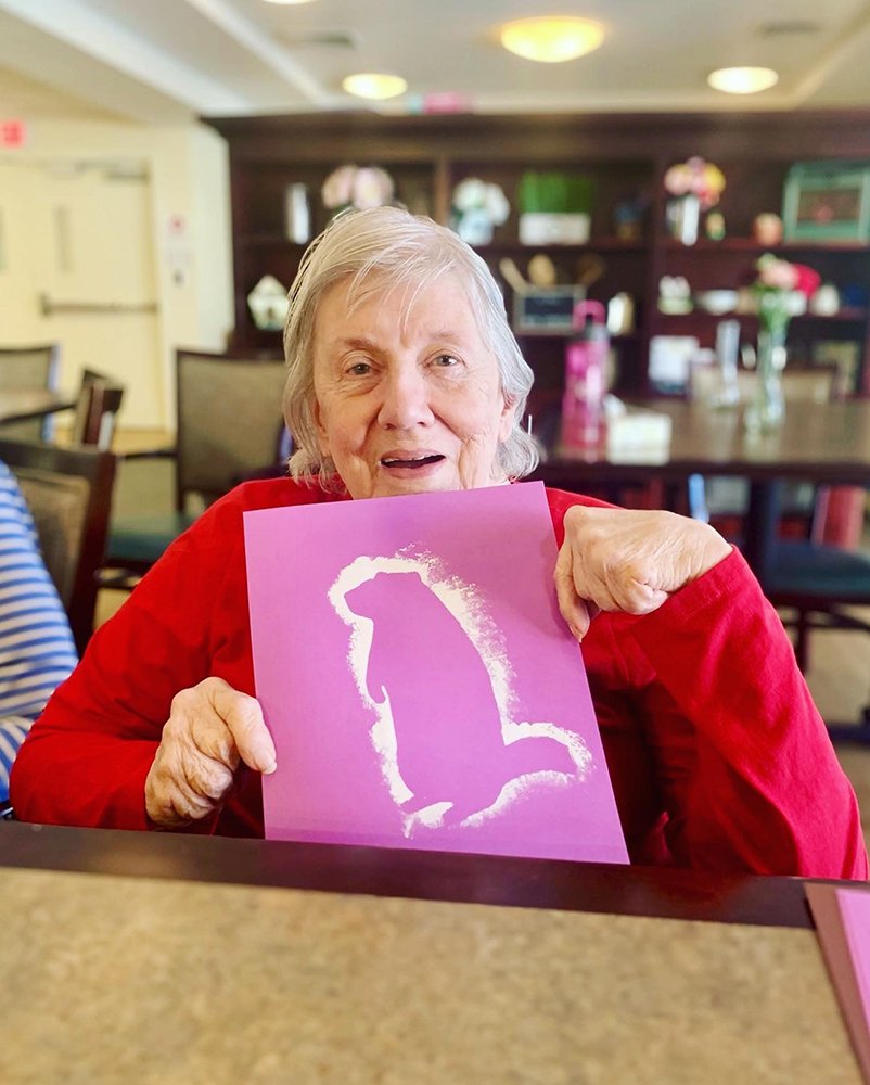 Resident holding artwork in a common area