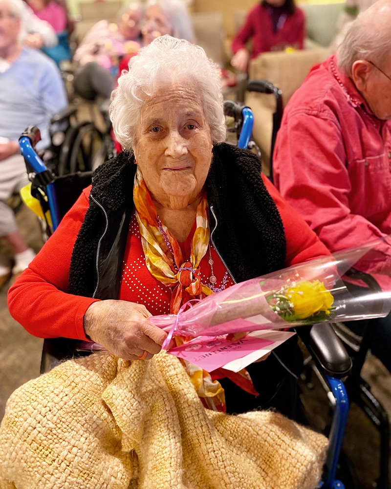 Resident holding a flower during a celebration