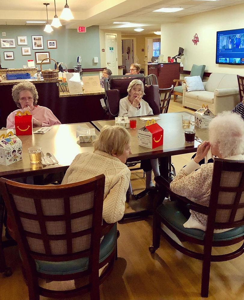 Residents engaging at a common table during mealtime