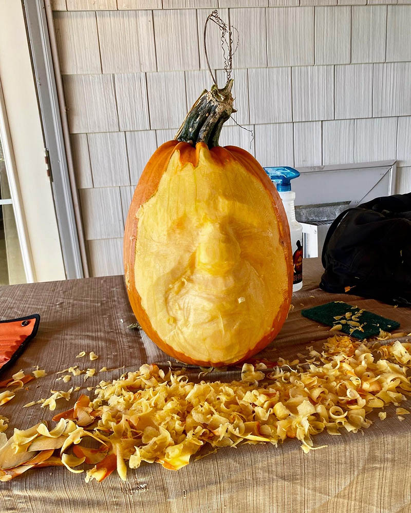 Pumpkin carving in progress with shavings scattered