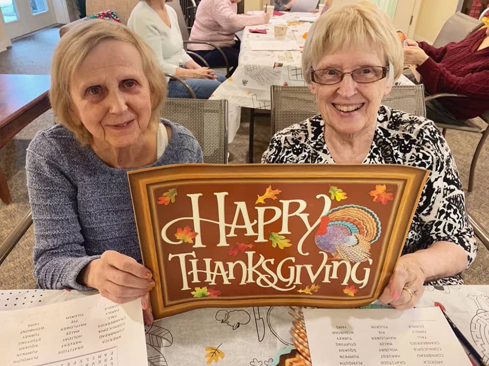 Residents celebrating Thanksgiving with a festive sign