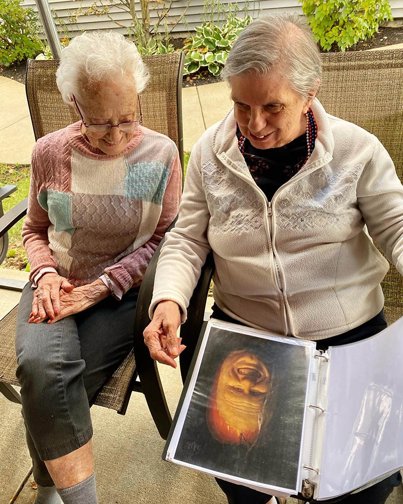 Two residents engaged with a photo album outdoors