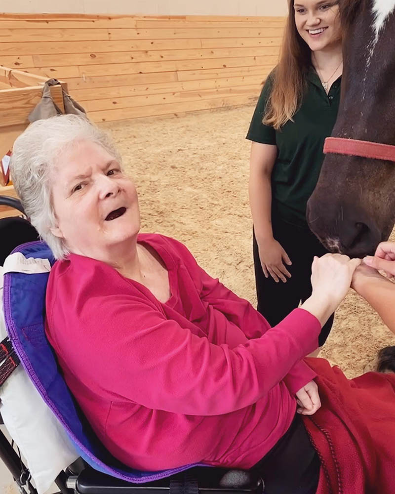 Resident interacting with a horse during a therapy session
