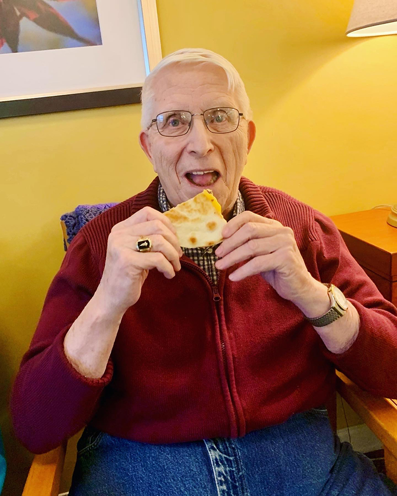 Senior resident enjoying a meal in a cozy indoor setting