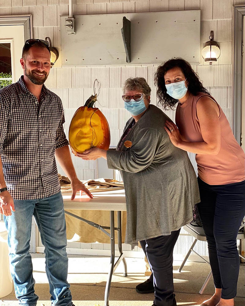 Residents and staff celebrating with a pumpkin