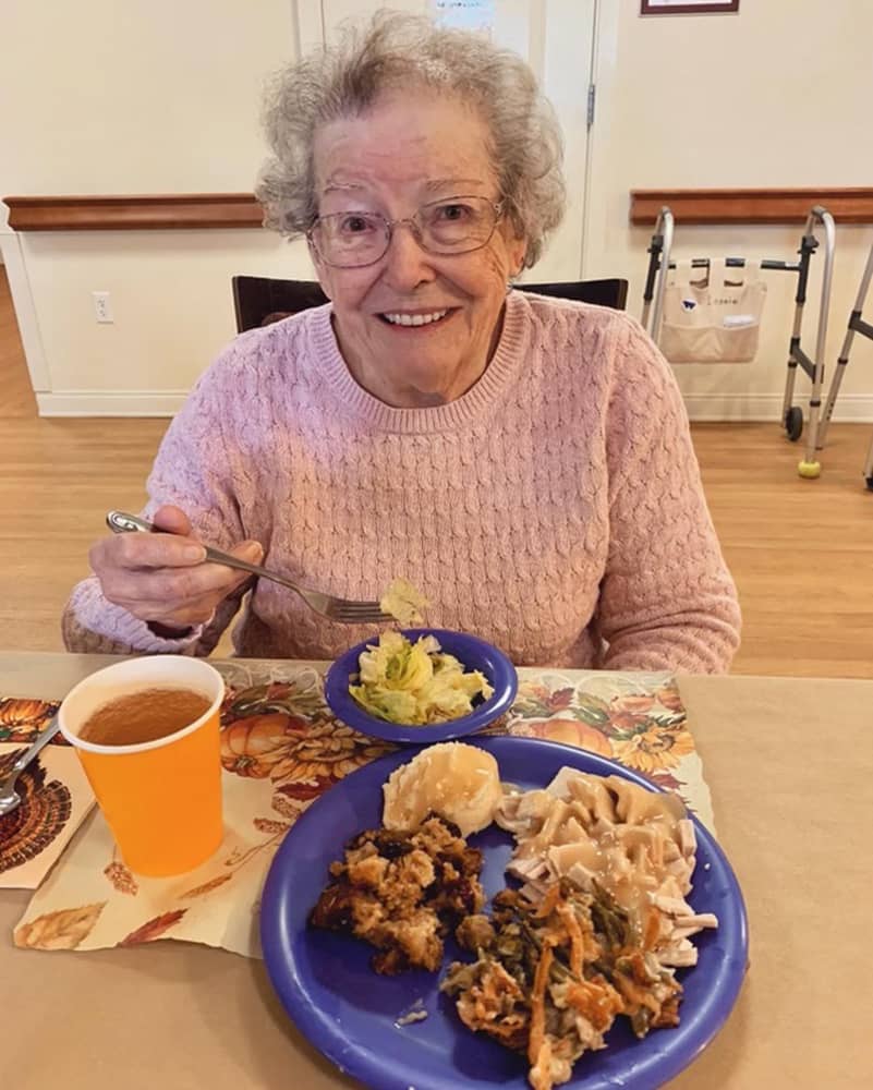 Resident enjoying a meal at the dining table