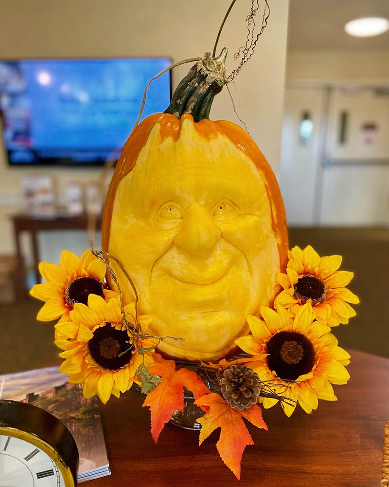 Carved pumpkin decoration with sunflowers