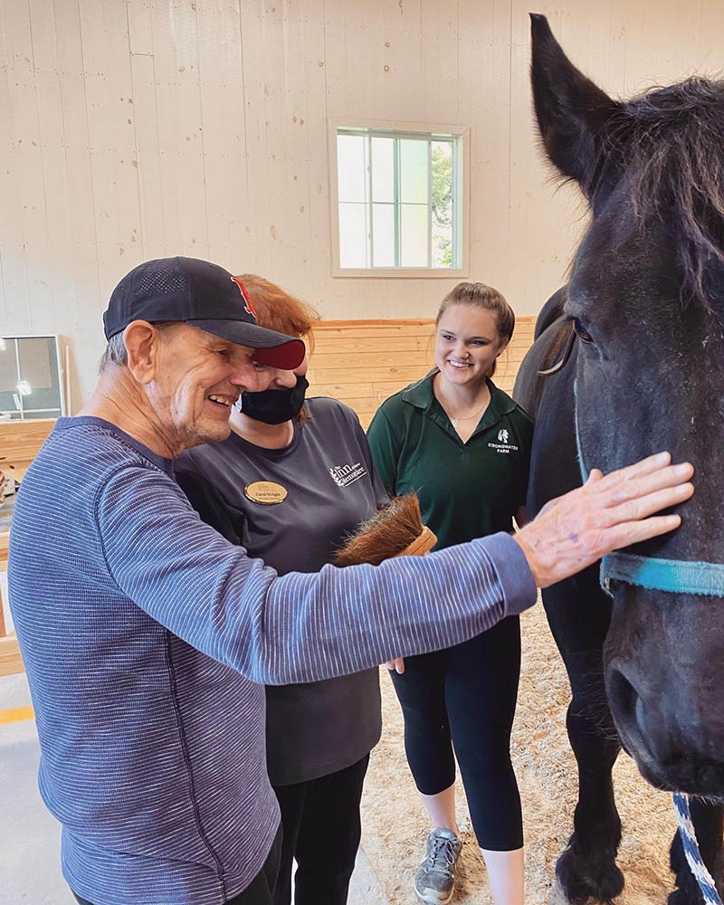 Residents enjoying interaction with a therapy horse