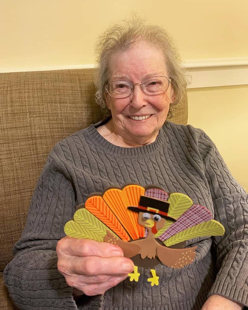 Resident holding a festive turkey decoration
