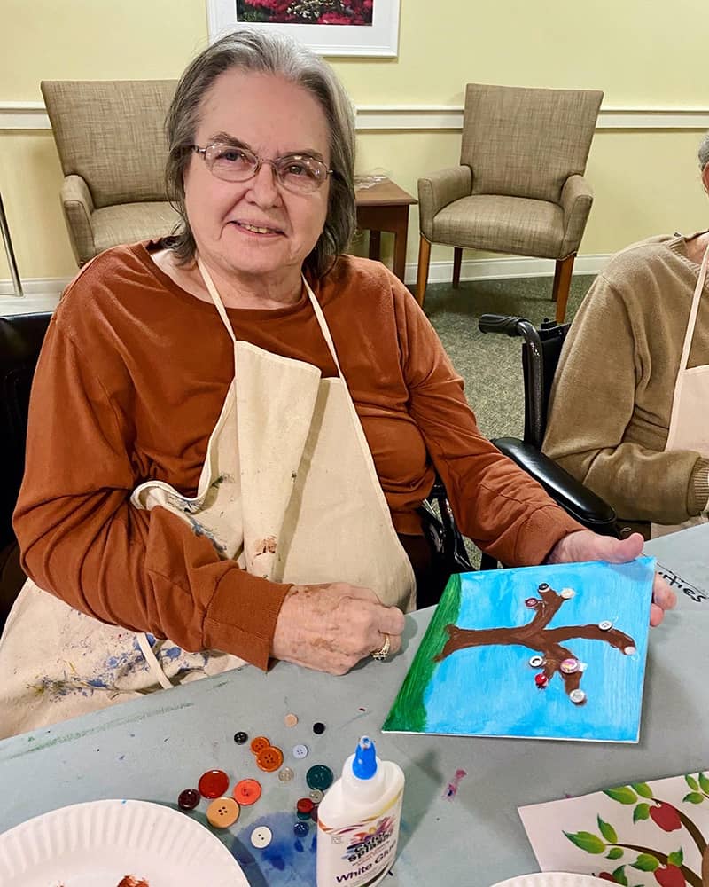 Resident participating in an art activity with a painting