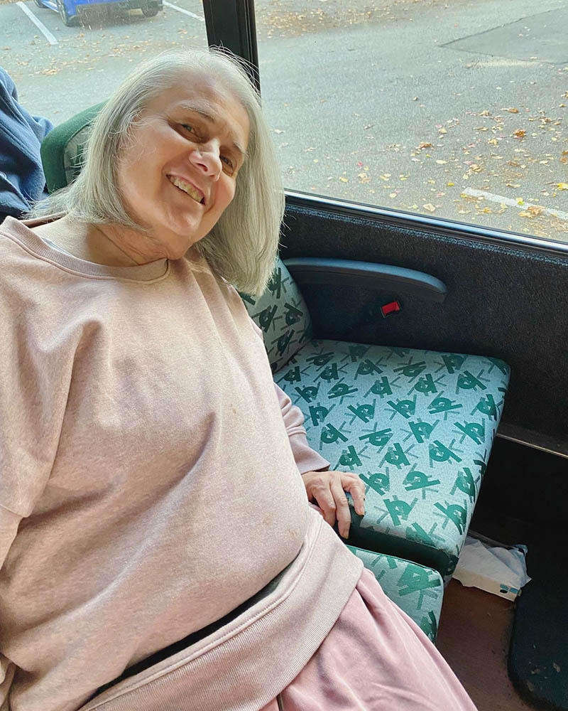 Resident smiling while seated in a vehicle