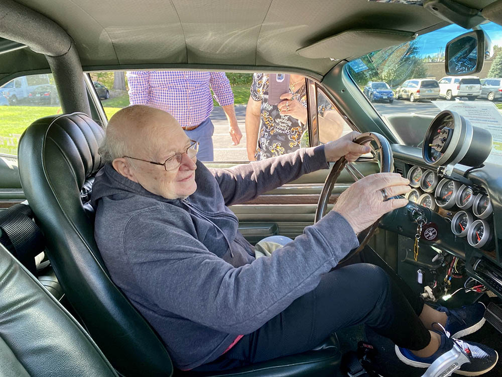 Senior man enjoying an experience inside a vintage car