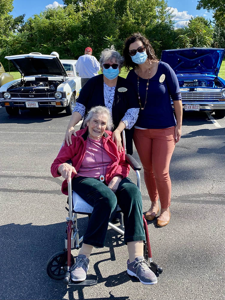 Residents and staff enjoying an outdoor event with classic cars