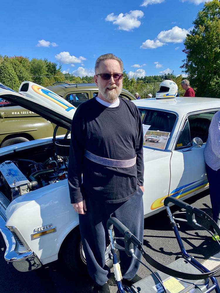 A resident with a classic car at an outdoor event