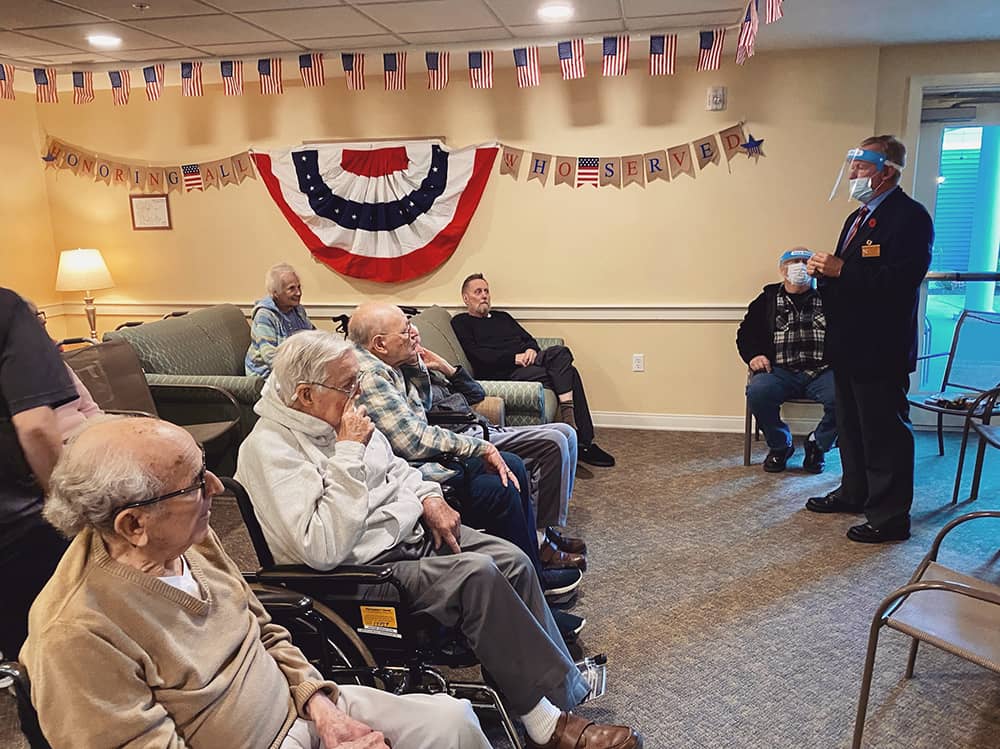 Residents attending a celebration event with an officer speaking