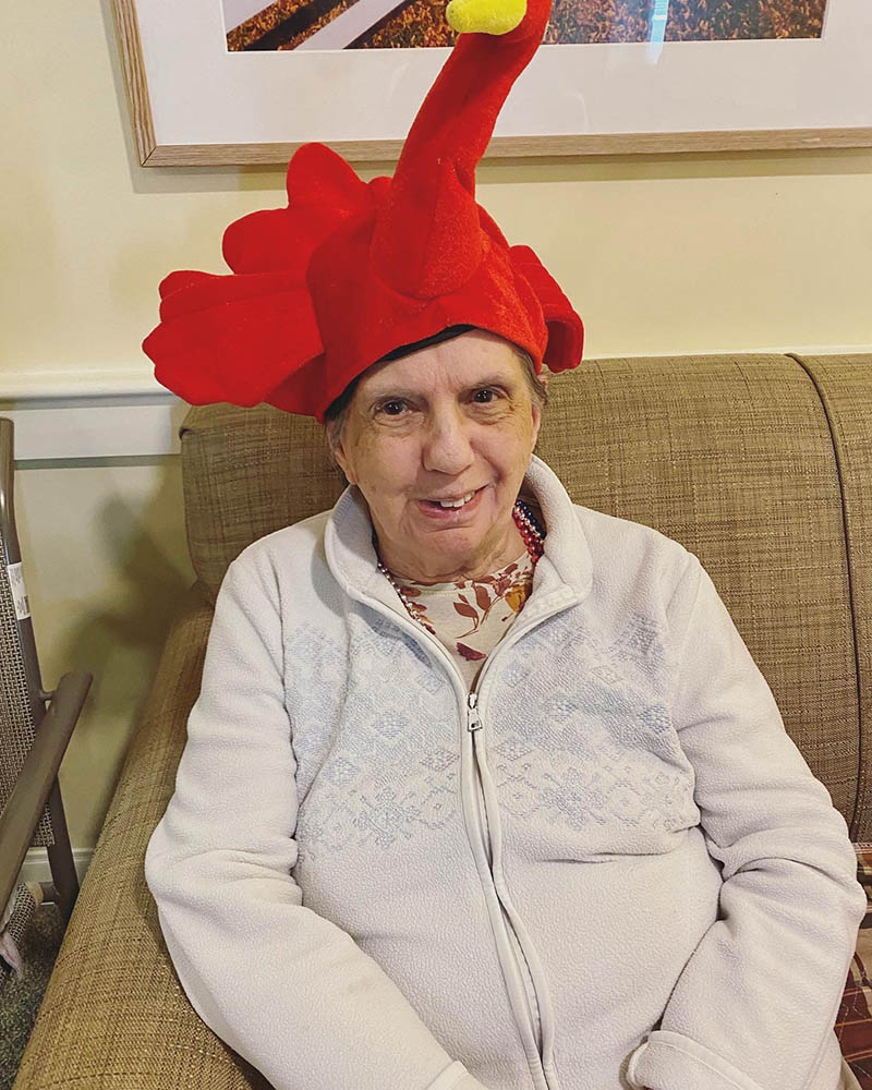 A resident wearing a playful red turkey hat