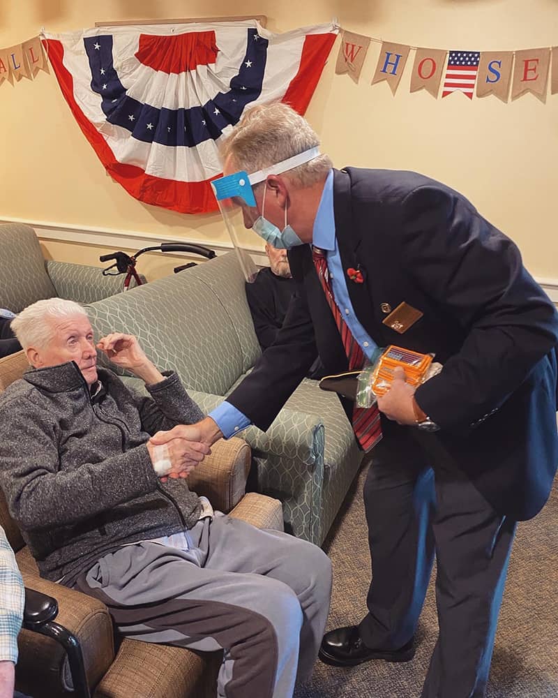 Staff member shaking hands with resident in a common area
