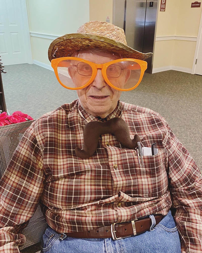 Resident dressed in playful costume with oversized glasses