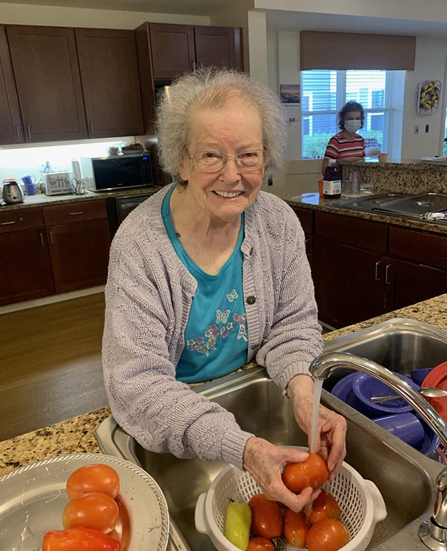 Resident washing tomatoes in the kitchen