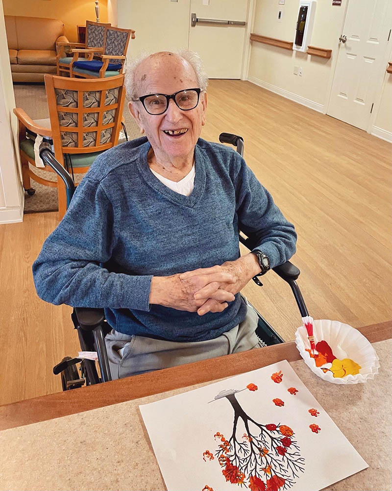 Resident enjoying a painting activity in the common area