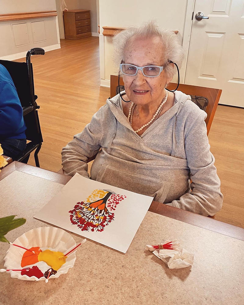 Elderly resident painting in an activity room