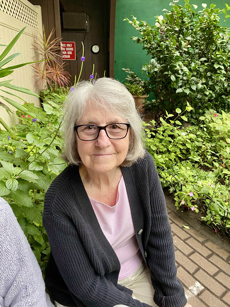 Resident enjoying outdoor greenery with flowers