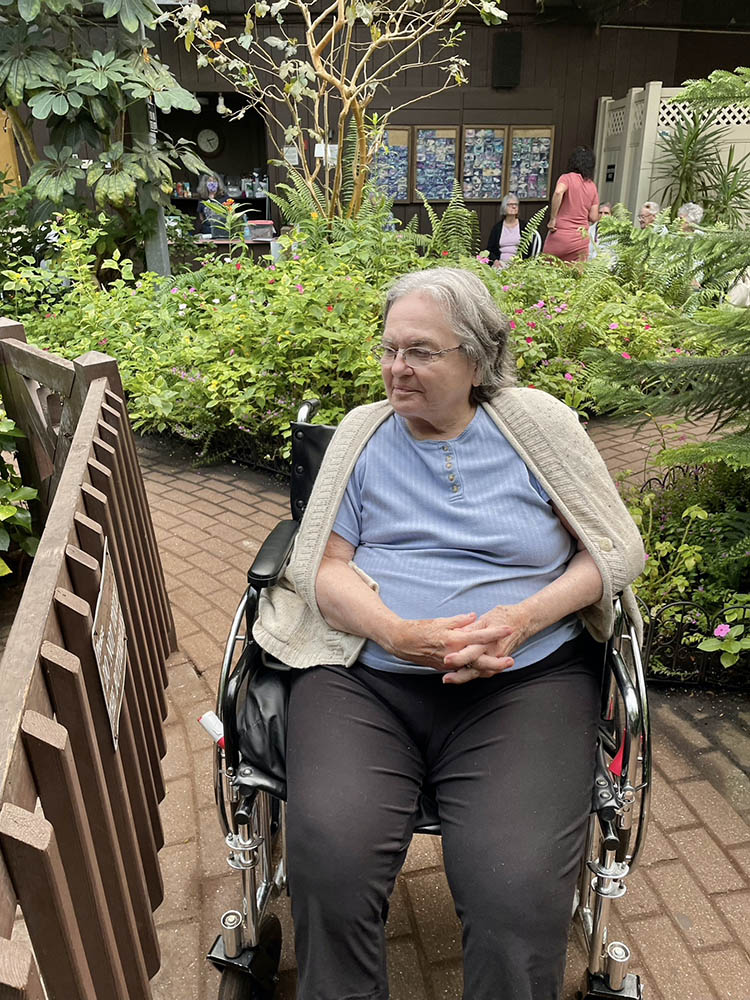 Resident in a wheelchair enjoying a garden space