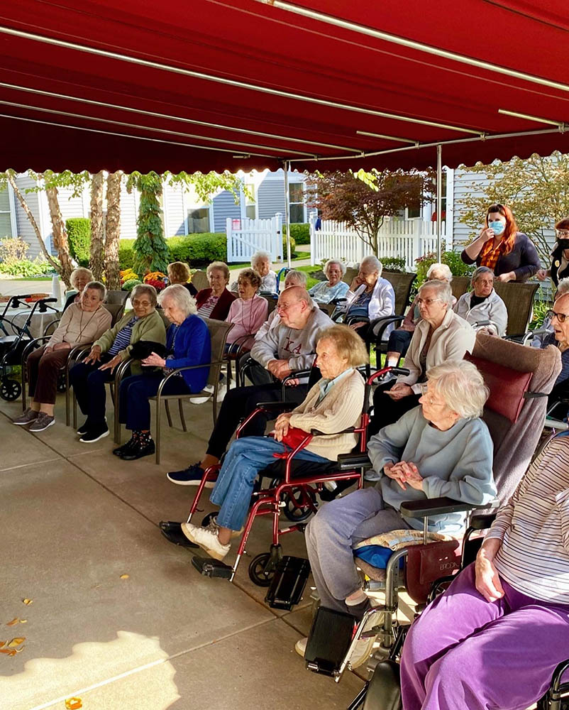 Residents seated outdoors under a canopy for an event