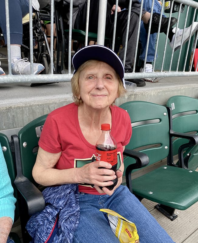 Elderly woman enjoying a drink at an event