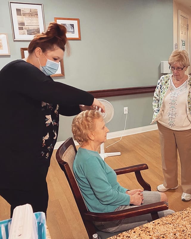 Residents and staff engaging in personal grooming activity