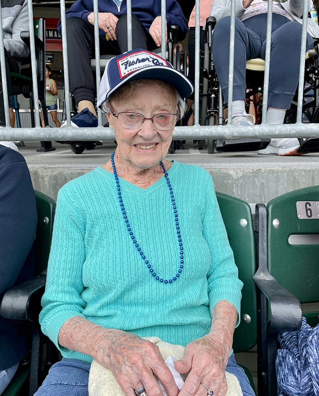 Elderly woman at a sports event wearing a cap
