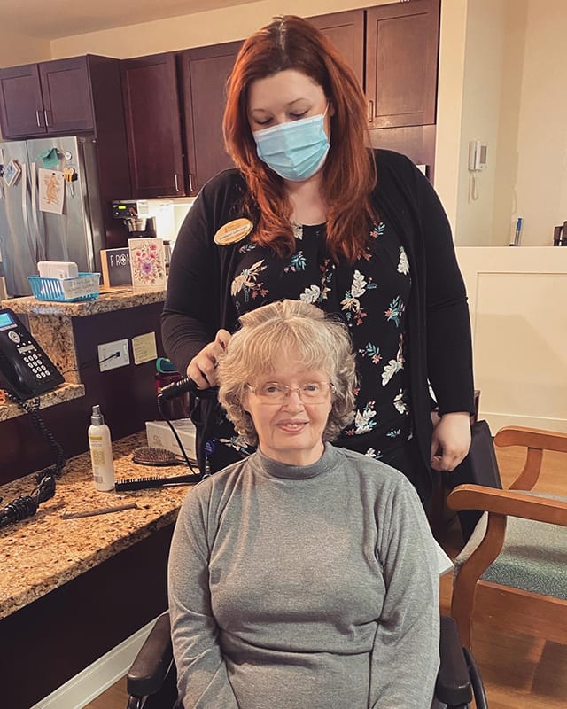Resident receiving hair care in a facility salon