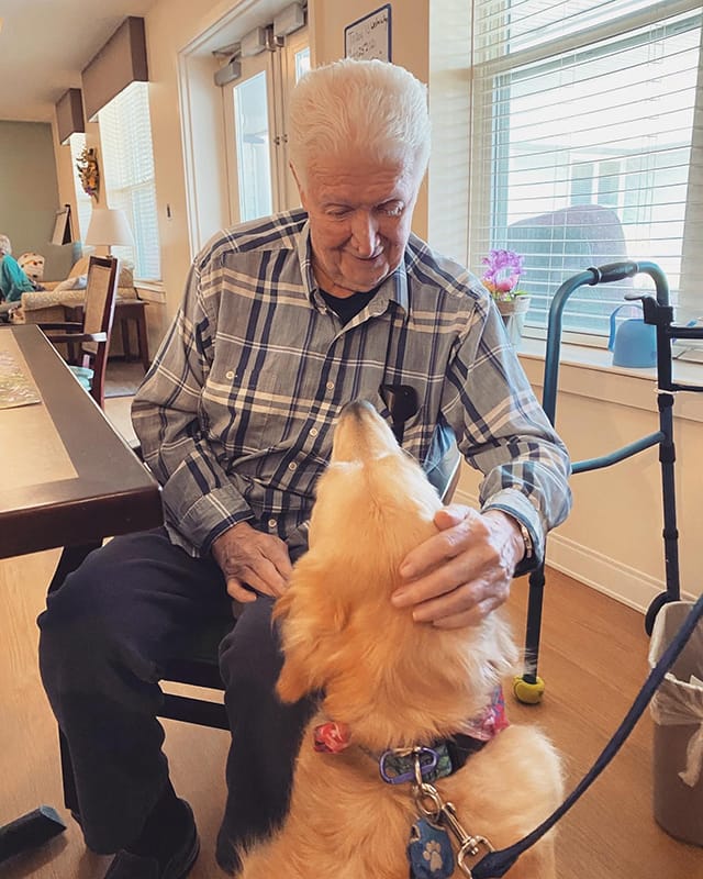 Resident interacting with a dog in a common area