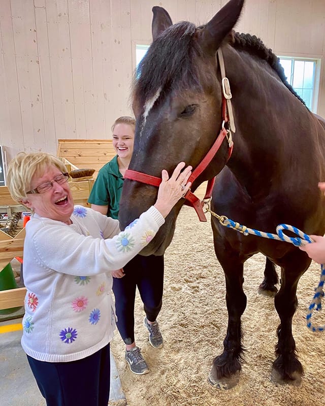 A resident enjoying time with a horse