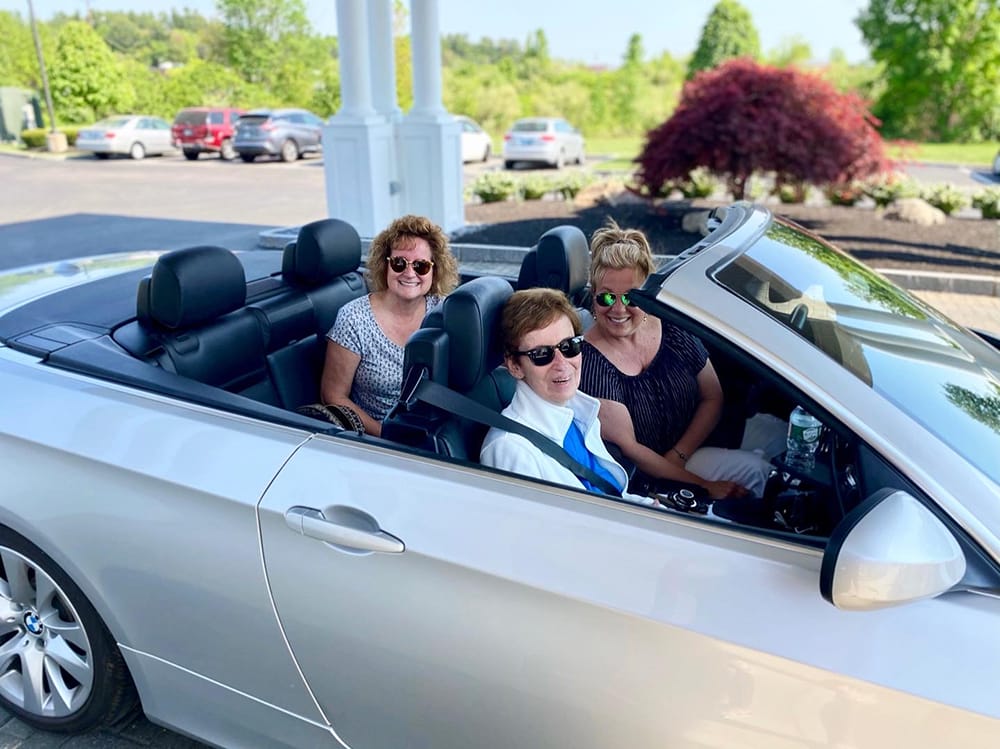 Three women in a convertible outside the facility