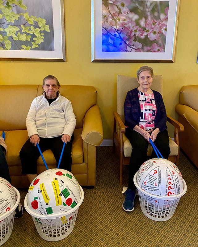Residents participating in an indoor activity with baskets.