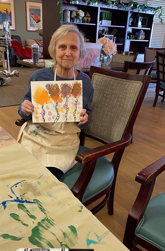Resident painting in a common area during an art activity