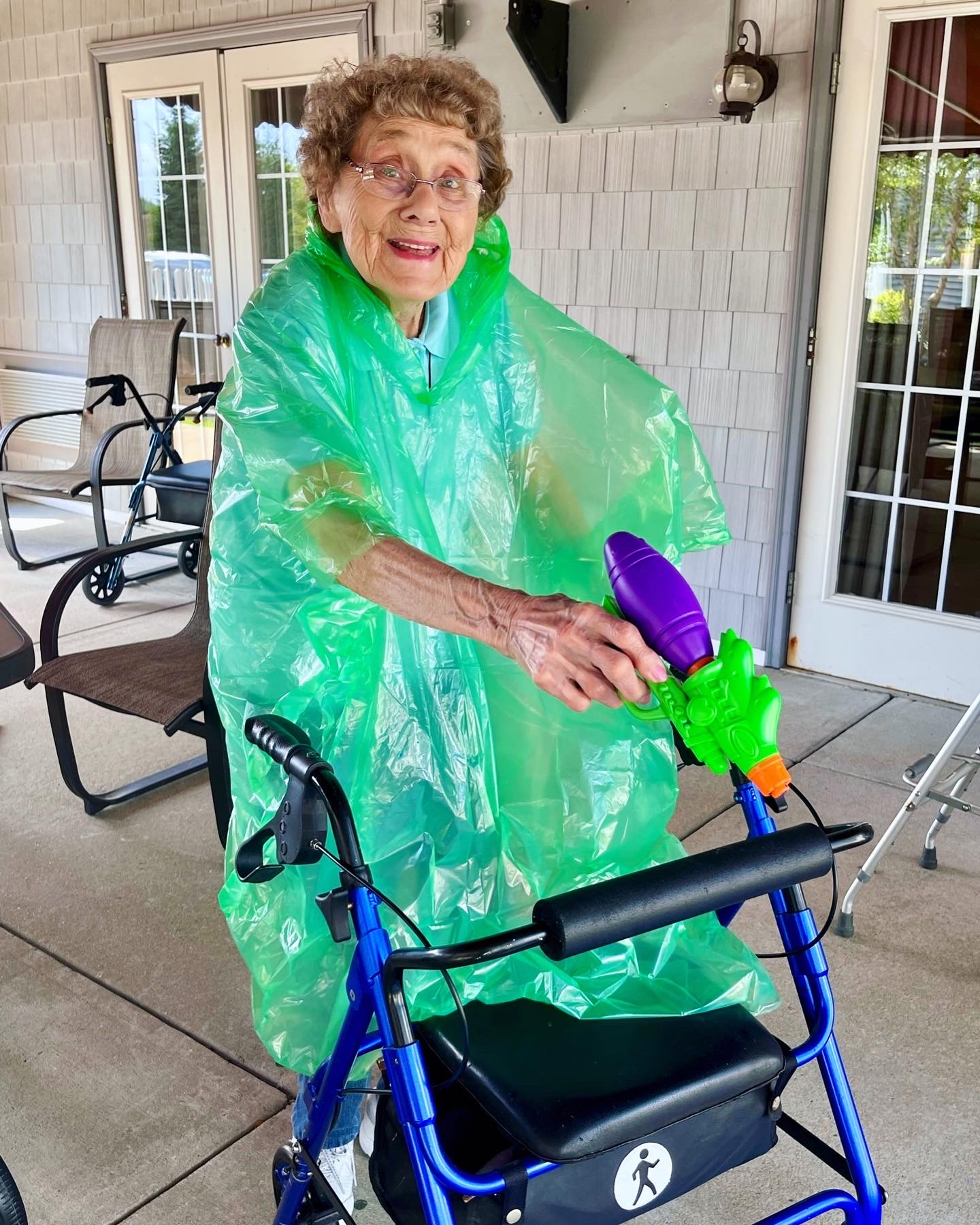 Resident enjoying a playful moment in a green poncho outdoors