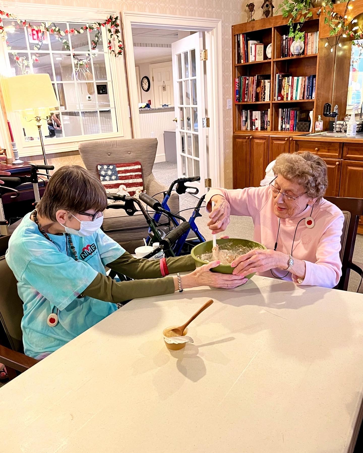 Resident and staff member cooking together in a common area