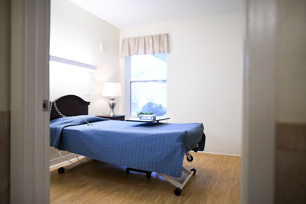 A well-furnished private resident room with a bed and lamp