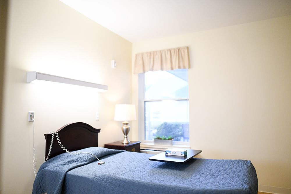 A private resident room with a neatly made bed